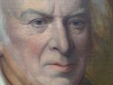 portrait of a man with white hair and a black jacket