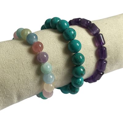 deux bracelets composés de perles de différentes couleurs posés sur une serviette blanche