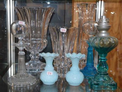 de nombreux vases en verre posés sur une étagère en verre