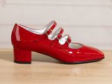 un gros plan sur une paire de chaussures rouges posées sur une table en bois