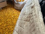 a bed that is in a room with a lot of clothes on it