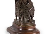 statue en bronze représentant une femme assise sur une chaise avec un chien