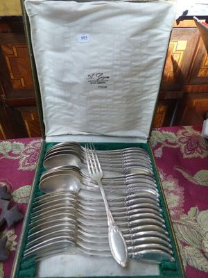 un coffret vert contenant de l'argenterie sur une table