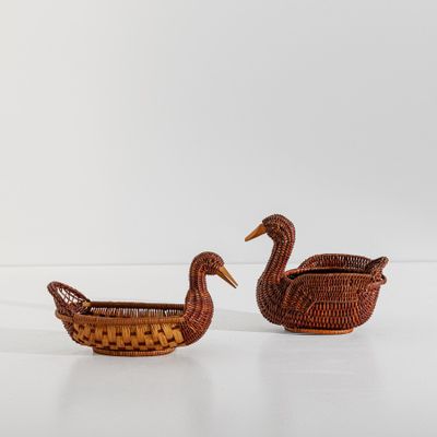 deux petits paniers en osier ornés de canards, posés sur une surface blanche