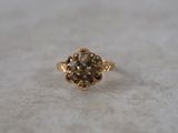 a close up of a gold ring with a brown diamond