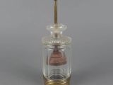 a small glass jar with a wooden lid and a metal handle