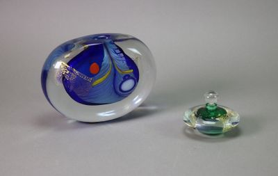 un objet en verre posé à côté d'un petit objet en verre