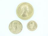 trois types différents de pièces d'or sur une surface blanche