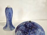 deux vases bleus posés l'un à côté de l'autre sur une surface blanche