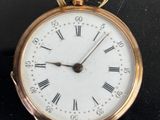 a gold pocket watch with roman numerals on the face