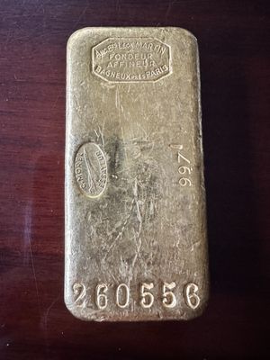 un vieux lingot d'argent posé sur une table en bois