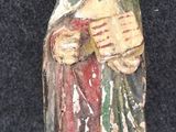 une statue représentant un homme tenant une croix entre ses mains