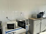 two microwaves sitting on top of a counter in a kitchen