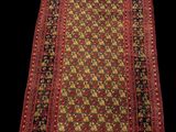 un tapis rouge et noir à franges sur fond noir