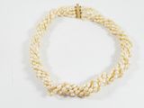gros plan d'un collier de perles blanches sur une surface blanche
