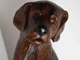a wooden statue of a dog that is sitting on a table