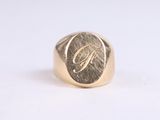 a close up of a gold signet ring with the letter g on it