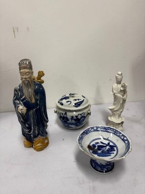 three figurines and a bowl on a table