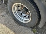 a close up of a flat tire on the side of a truck