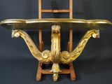 a gold plate on a wooden stand with a chair in the background