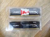 the two memory modules are in plastic cases on a wooden table
