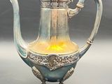 a silver tea pot with a lit candle inside of it