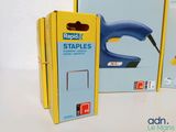 a box of staples and a stapler sitting on a table