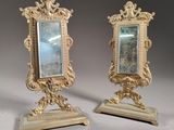 pair of antique mirrors on stands on a grey background