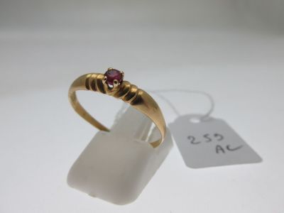 un gros plan d'une bague en or sertie d'un rubis