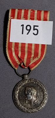 a silver medal with a red ribbon around it