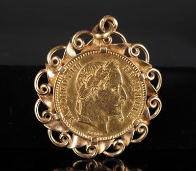 un pendentif en forme de pièce d'or sur lequel est gravé le visage d'une femme