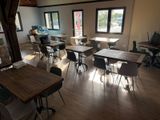 many tables and chairs in a room with a lot of windows