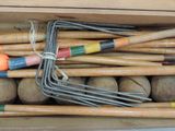 a box full of wooden croquets and balls