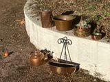 pots and pans are hanging on a wall in a garden