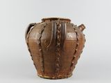 a brown vase that is sitting on a white surface
