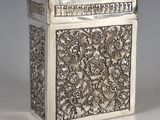 an antique silver box with a floral design on the front