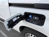 a white van with an electric charger attached to it ' s side