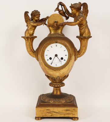 une horloge dorée ornée d'anges sur fond blanc