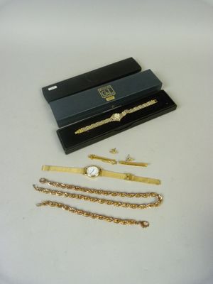 a black box with a gold chain bracelet and a watch