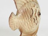 a ceramic fish figurine on a white surface