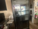 a refrigerator in the middle of a room with a tv on the wall