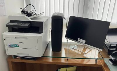 a glass desk with a computer and a printer on it
