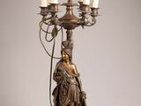 an image of a bronze statue of a woman holding a candelabra