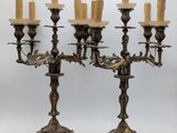 a pair of antique brass candelabs with candles on them