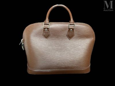 a close up of a brown handbag on a black background