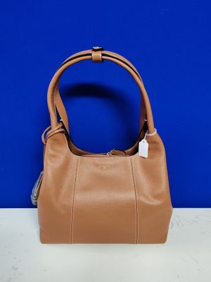 a brown purse sitting on top of a table next to a blue wall