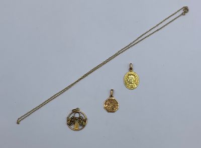 trois pendentifs en or et une chaîne sur un fond blanc