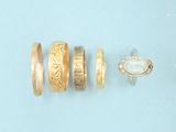 several different types of gold rings on a blue surface
