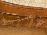 a close up of a wooden chair with peeling paint on it