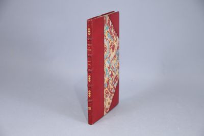 Le livre est rouge et comporte un motif doré.